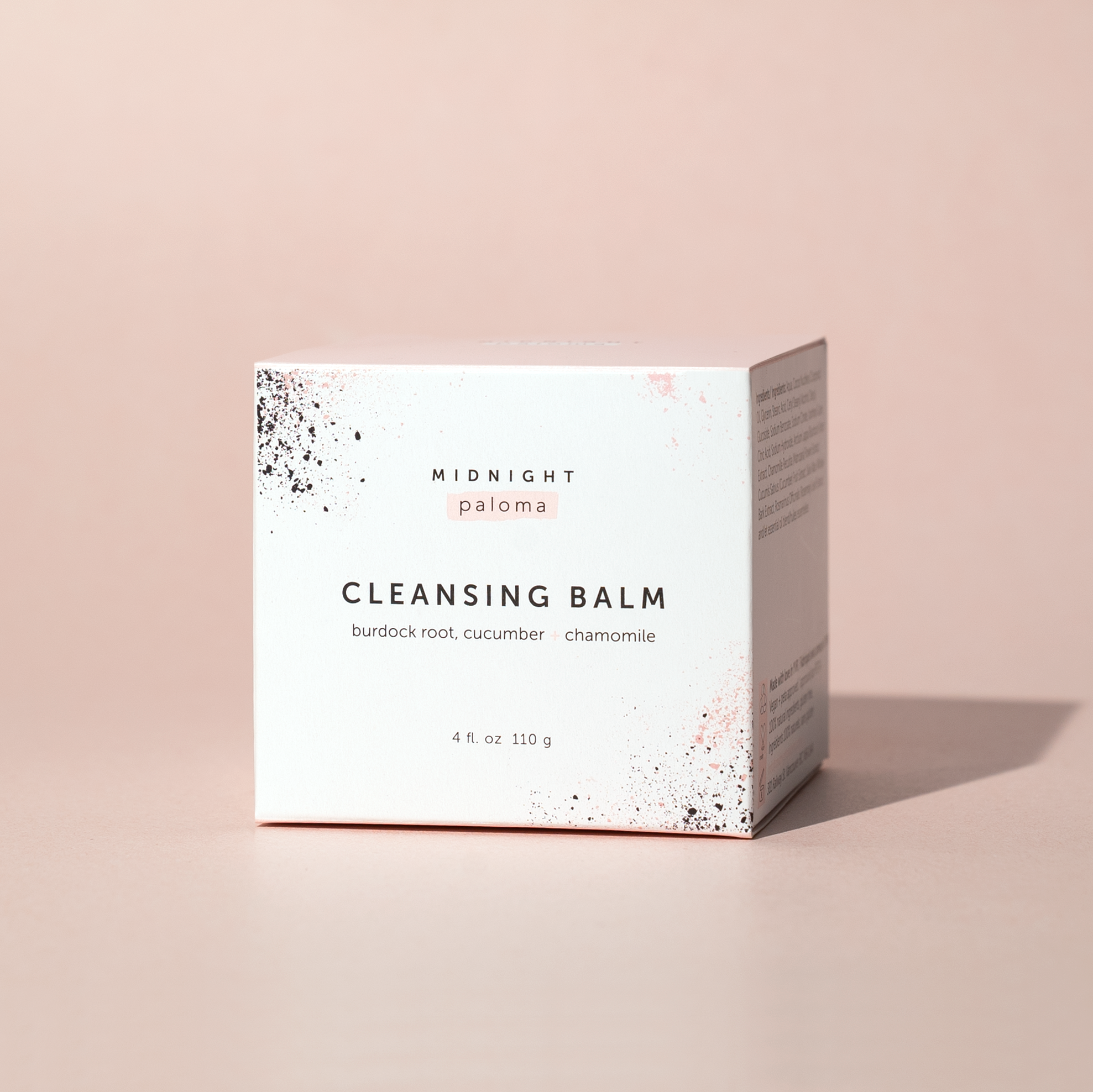 A jar of cleansing balm with a label that reads 'Cleansing Balm' and lists burdock root, cucumber, and chamomile as ingredients. There is a seal of approval from a beauty awards ceremony displayed in the top right corner.
